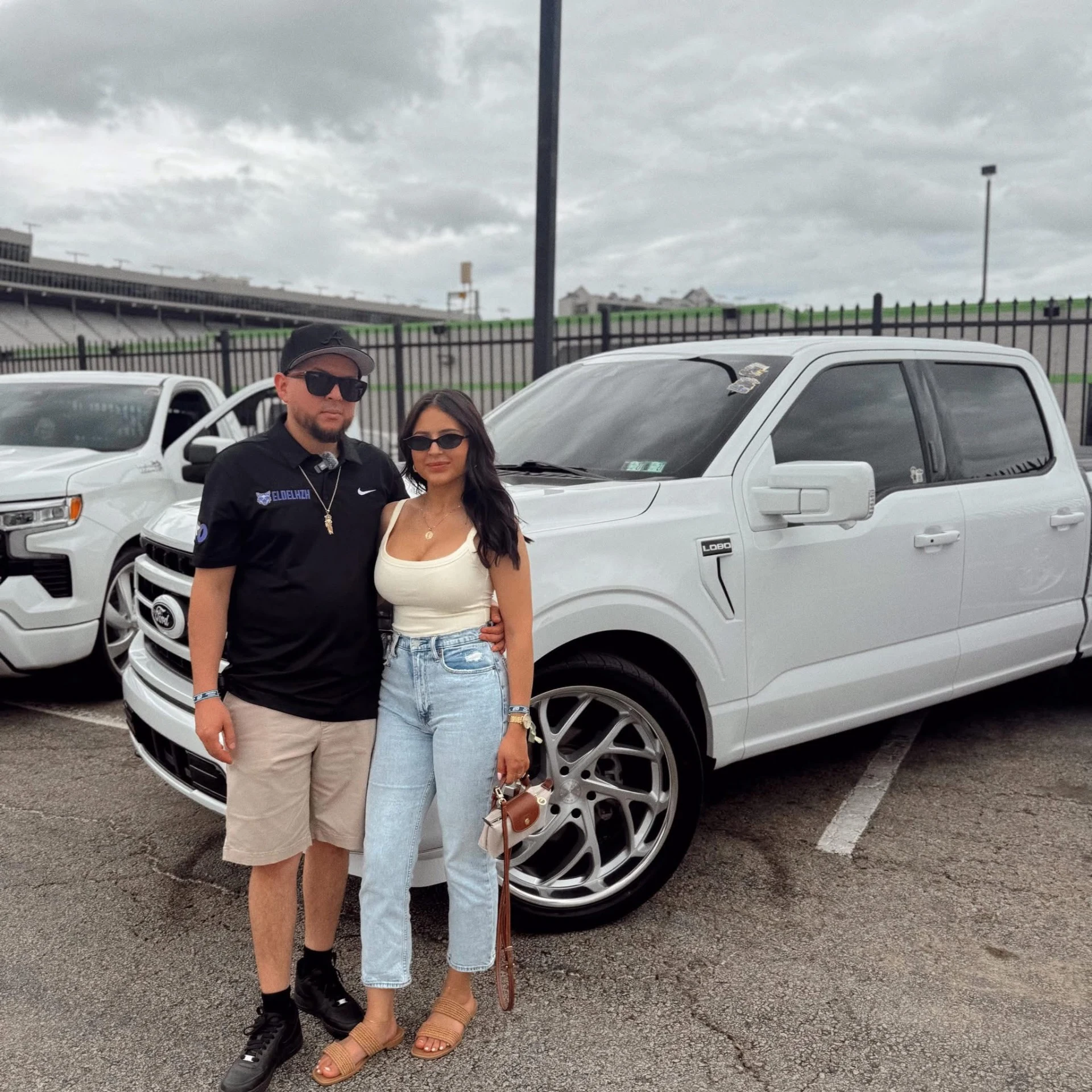 Flavio Montes Jr., owner and window tint installer, beside his fiancée and white Ford truck